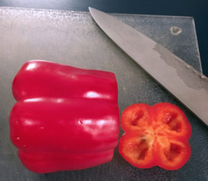 Start cutting pepper by slicing off roundness of the lobes at the bottom
