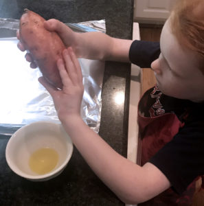 Get kids cooking - oiling sweet potatoes to roast