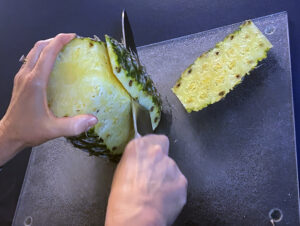 Removing the prickly outside of a pineapple