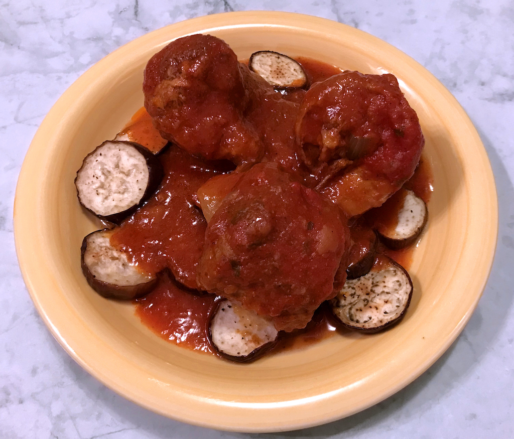 Pigs in a blanket served over roasted Japanese eggplant