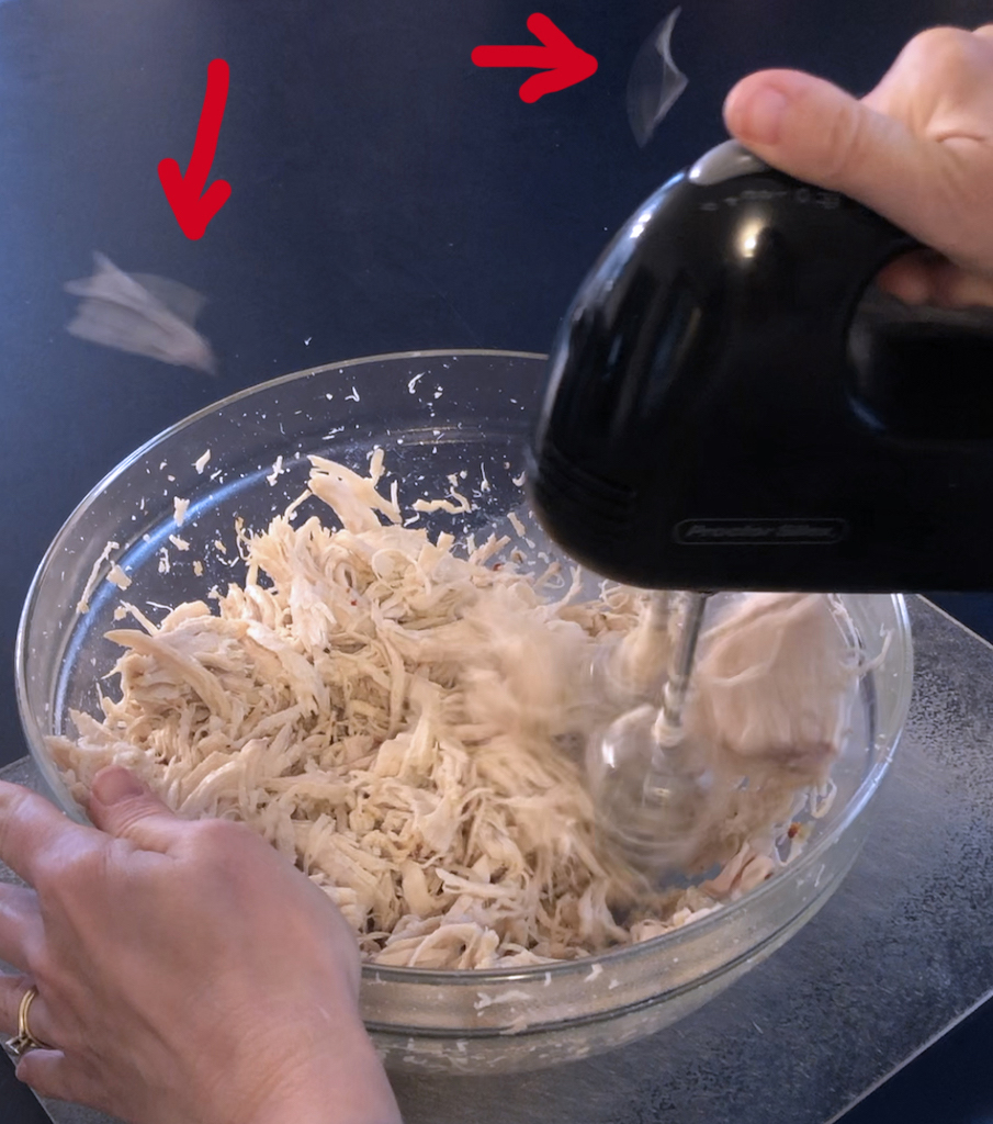 Shredding with a hand mixer gets chicken bits flying around the room